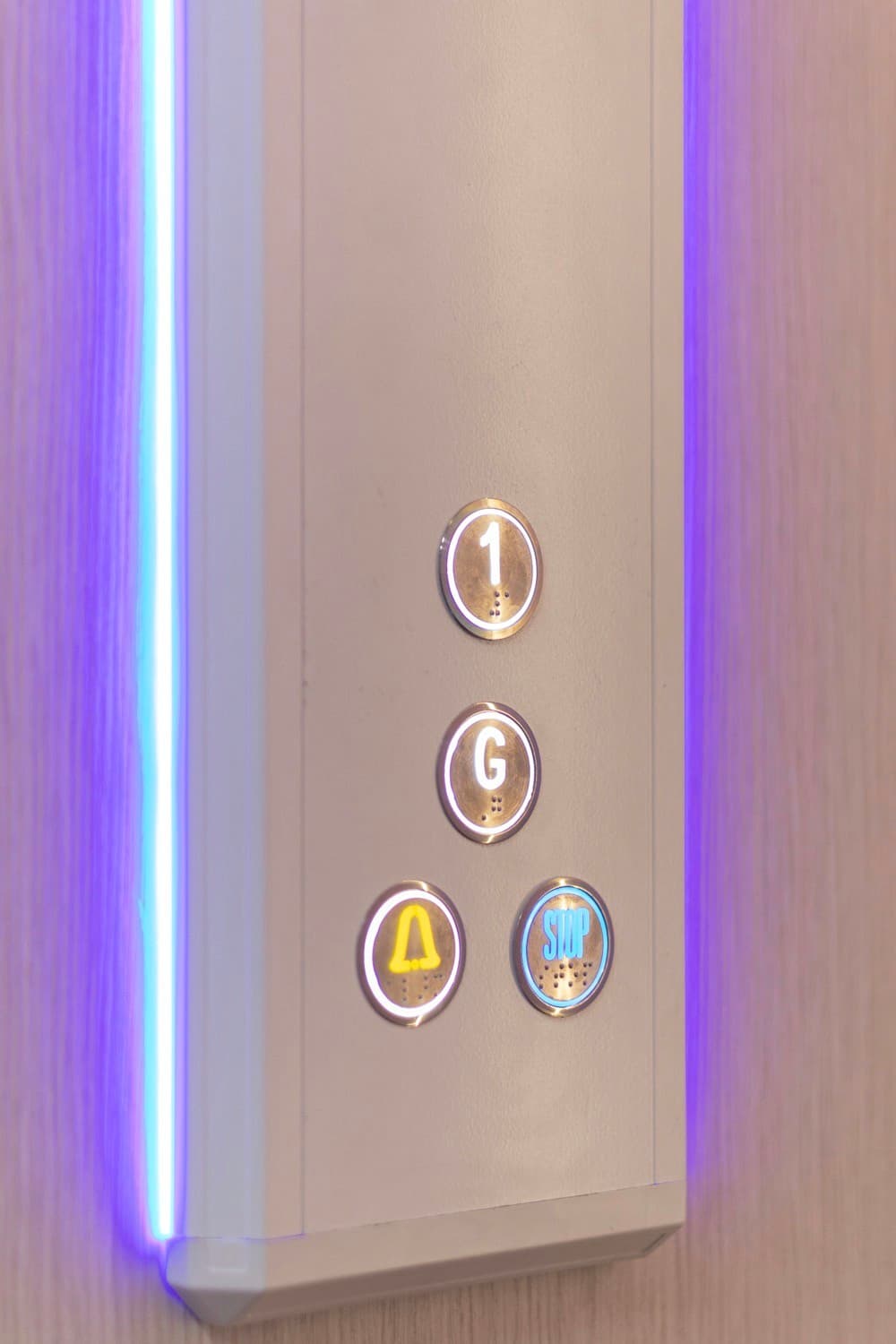 Lift car control panel with braille buttons for floors 1 and G, alarm and stop, edged with a blue LED light strip